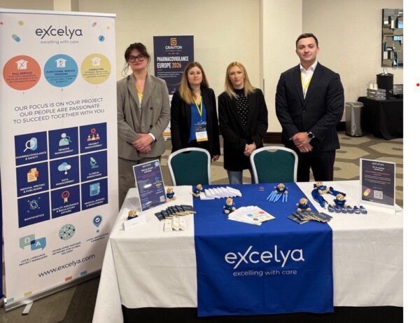 Équipe Excelya à Pharmacovigilance Europe 2026 avec un stand aux couleurs de la marque.